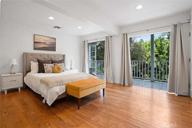 bedroom featuring access to exterior, beam ceiling, and light hardwood / wood-style flooring