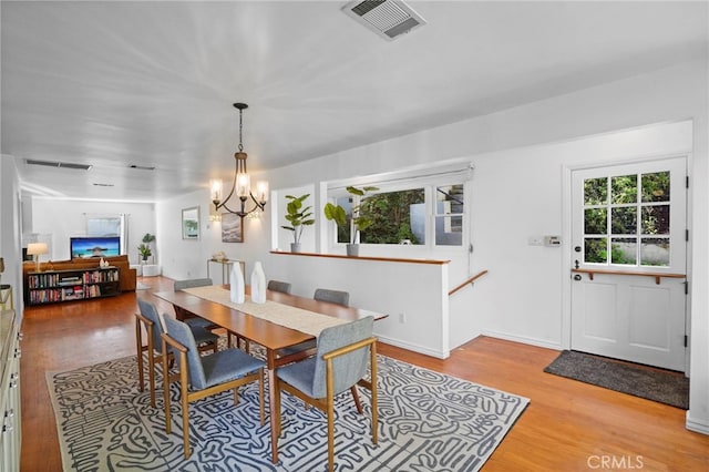 dining area with a notable chandelier and light hardwood / wood-style floors