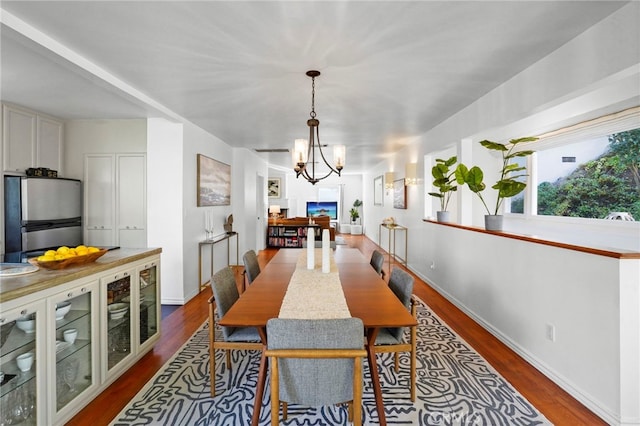 dining area with dark hardwood / wood-style floors and a chandelier