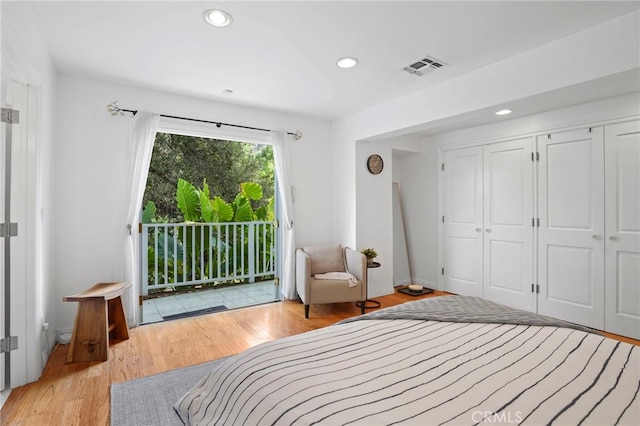 bedroom featuring access to exterior, light hardwood / wood-style flooring, and a closet