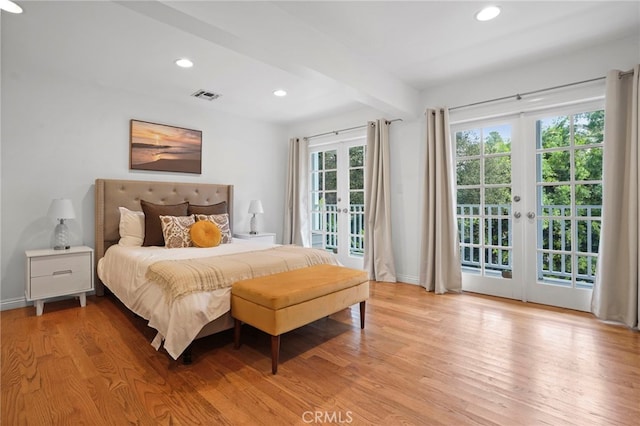 bedroom featuring beamed ceiling, access to outside, light hardwood / wood-style floors, and french doors