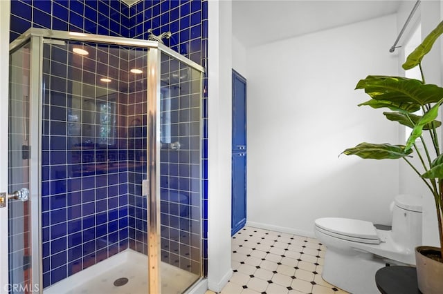 bathroom with toilet and a shower with shower door