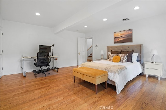 bedroom with light hardwood / wood-style floors and beamed ceiling