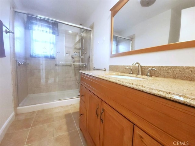 bathroom featuring vanity, a shower with shower door, and tile patterned floors