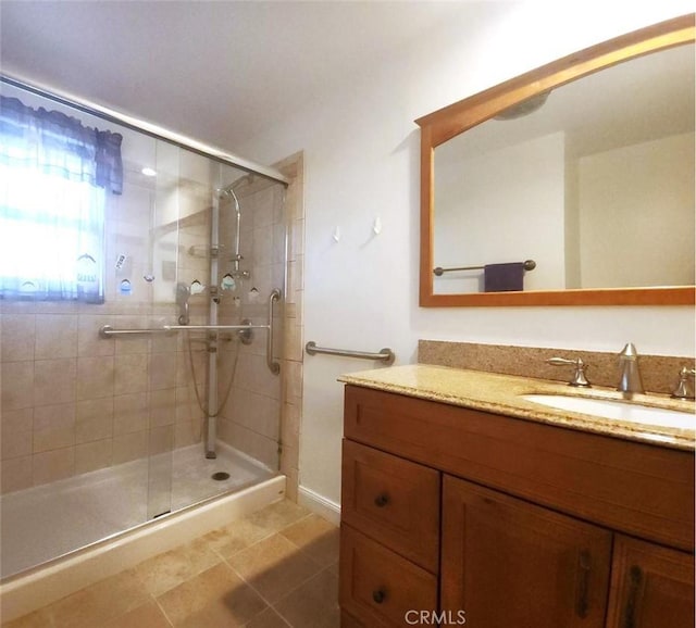 bathroom with vanity, a shower with shower door, and tile patterned floors