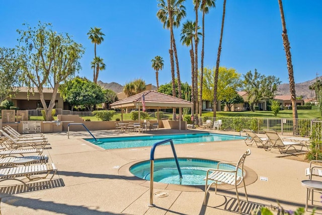 view of swimming pool featuring a patio, a mountain view, and a community hot tub