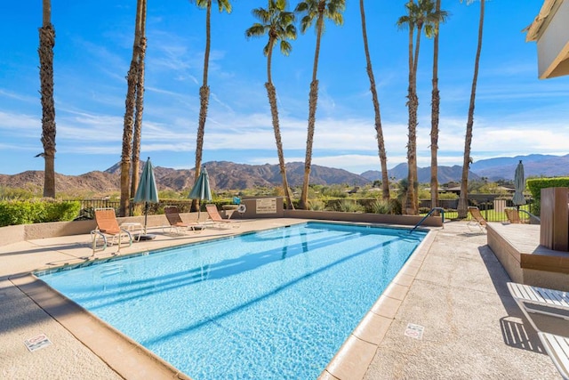 view of swimming pool with a mountain view and a patio area