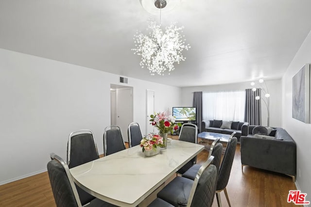 dining room featuring a notable chandelier and dark hardwood / wood-style flooring