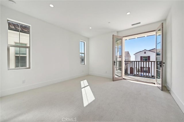 empty room featuring a healthy amount of sunlight and light colored carpet