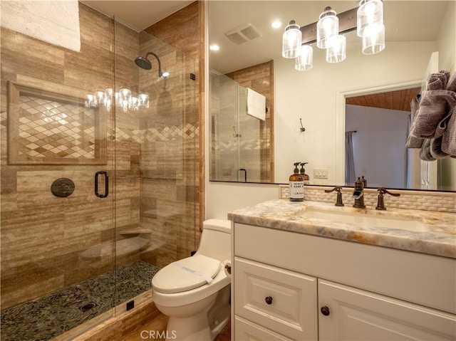 bathroom with vanity, toilet, and a shower with shower door