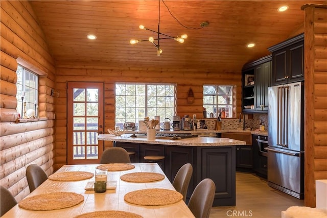 kitchen with log walls, stainless steel appliances, a center island, and a kitchen bar