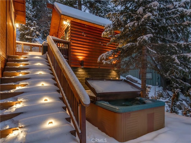 snow covered deck featuring a hot tub