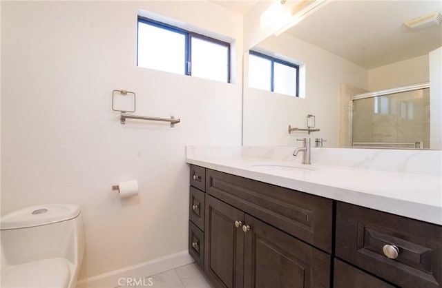 bathroom featuring a shower with door, vanity, tile patterned flooring, and toilet