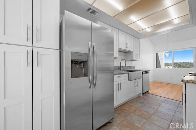 kitchen featuring pendant lighting, sink, stainless steel appliances, and white cabinets