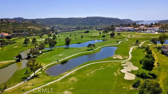 view of home's community with view of golf course and a water and mountain view