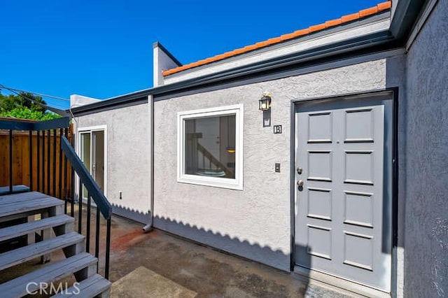 entrance to property featuring stucco siding