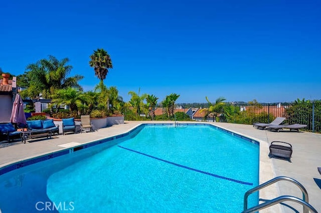 community pool with fence and a patio