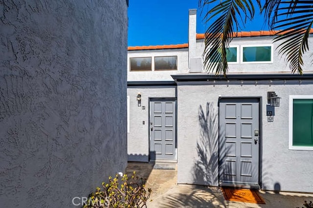 view of exterior entry with stucco siding