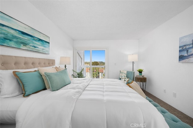 carpeted bedroom with access to outside and a textured ceiling