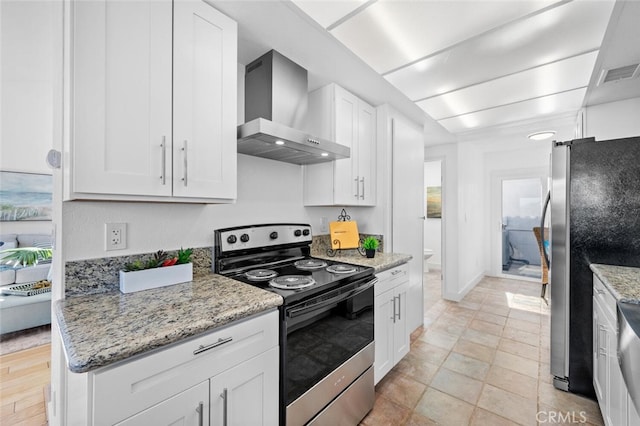 kitchen with visible vents, appliances with stainless steel finishes, white cabinets, wall chimney range hood, and light stone countertops