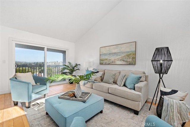 living room with high vaulted ceiling and light wood-style floors