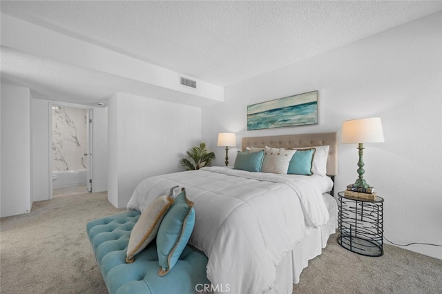 bedroom featuring light carpet, a textured ceiling, connected bathroom, and visible vents