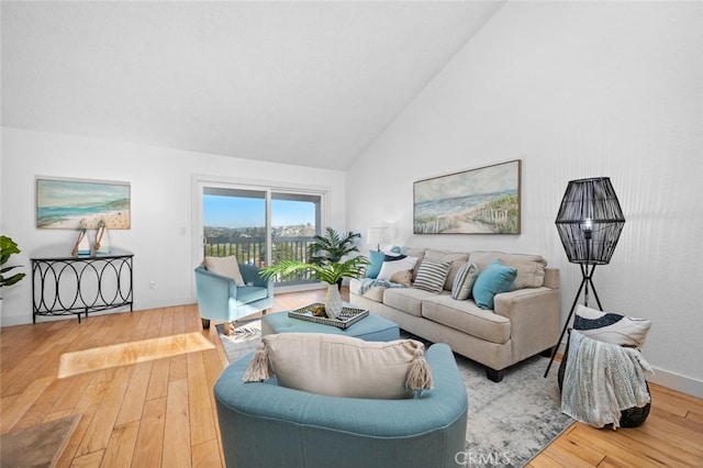 living area featuring high vaulted ceiling and wood finished floors