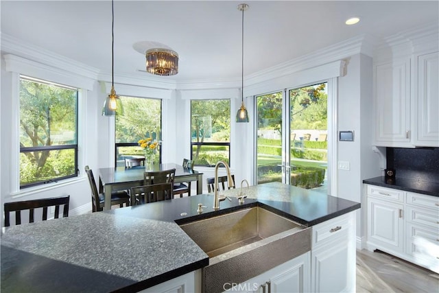 kitchen featuring a healthy amount of sunlight, sink, and white cabinets