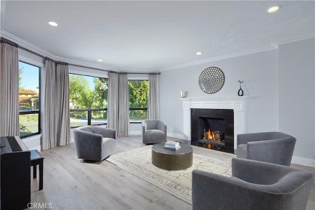 living room featuring crown molding, a healthy amount of sunlight, and light hardwood / wood-style flooring