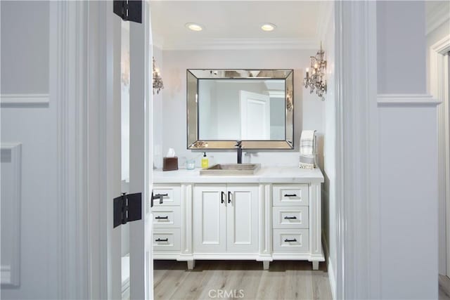 bathroom with vanity, wood-type flooring, and ornamental molding