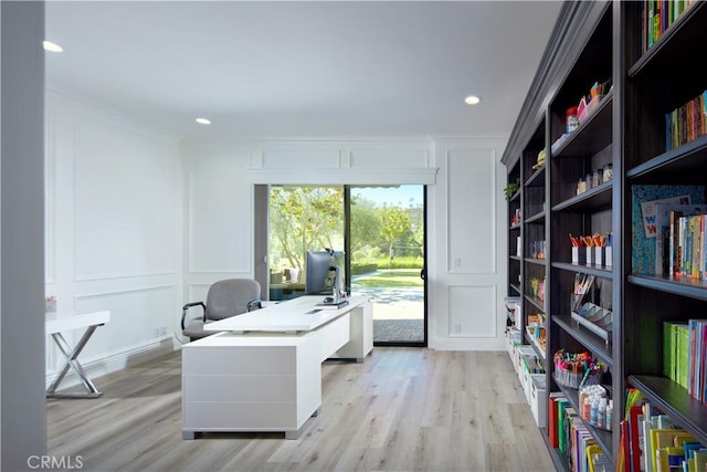 home office with ornamental molding and light hardwood / wood-style floors