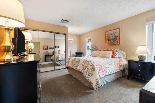 bedroom featuring dark carpet, a closet, and a textured ceiling