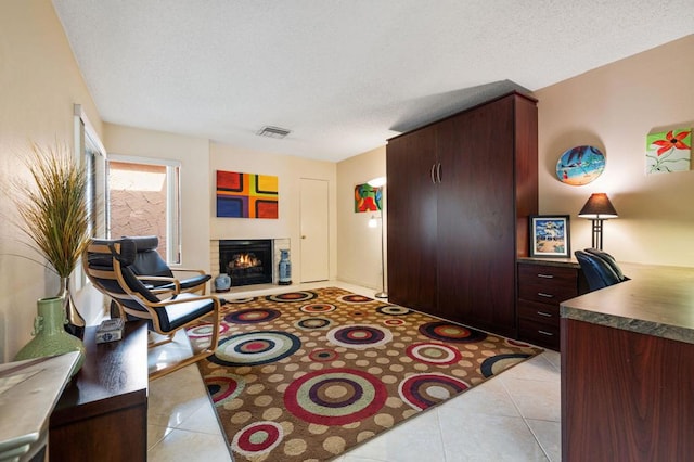 tiled living room featuring a textured ceiling