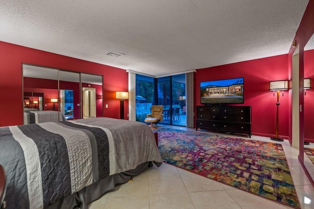 bedroom with light tile patterned floors and a textured ceiling