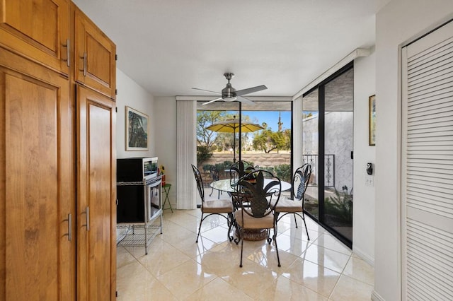 dining space with expansive windows and ceiling fan