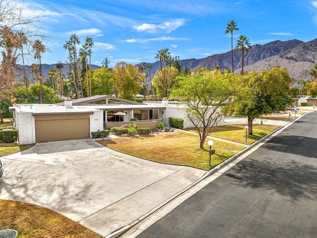 single story home featuring a mountain view, a garage, and a front yard