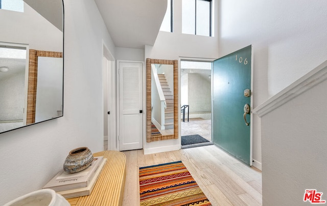 foyer with hardwood / wood-style floors and a towering ceiling