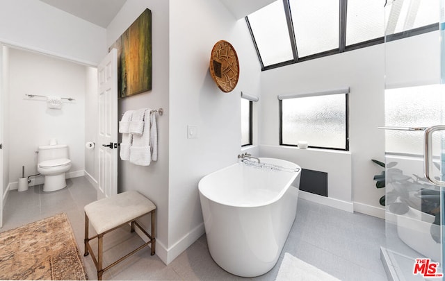 bathroom featuring tile patterned flooring, a bath, and toilet