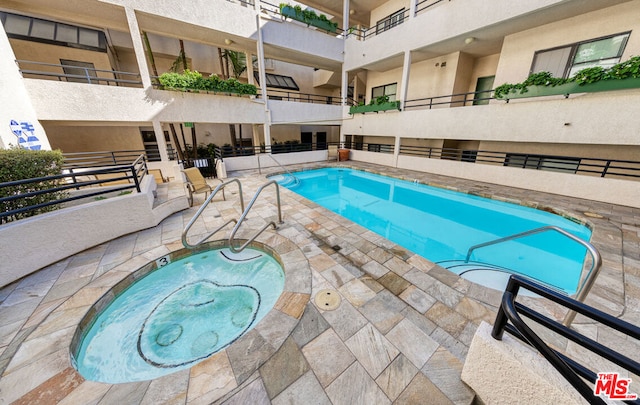 view of swimming pool with a community hot tub and a patio area