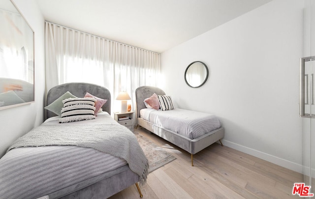 bedroom with lofted ceiling and light hardwood / wood-style flooring