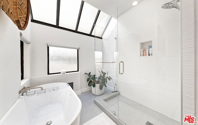 bathroom featuring vaulted ceiling, tile patterned flooring, independent shower and bath, and sink