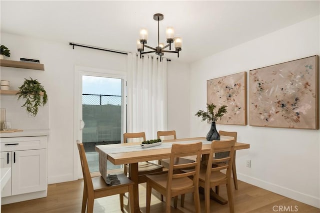 dining area featuring light hardwood / wood-style flooring and a chandelier