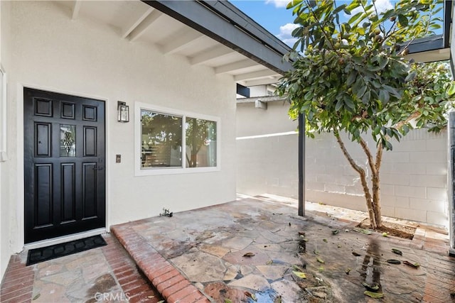 view of exterior entry featuring a patio area