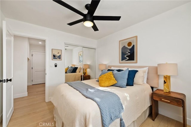 bedroom featuring light hardwood / wood-style flooring, ceiling fan, and a closet