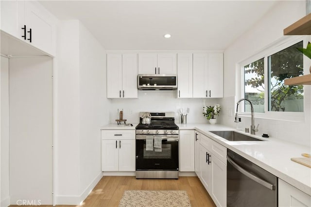 kitchen with sink, stainless steel appliances, and white cabinets