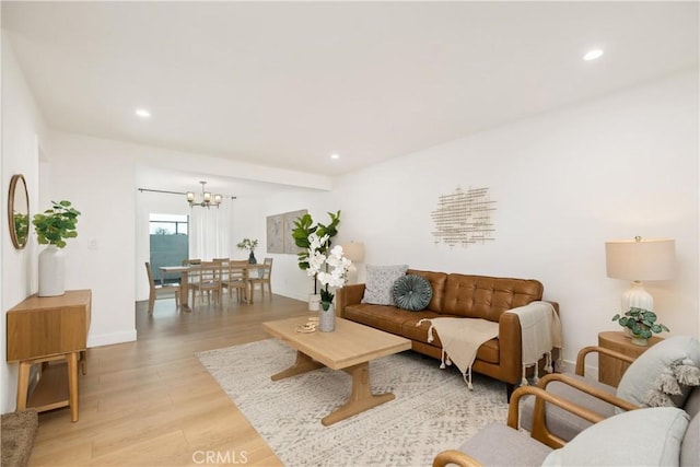 living room with a chandelier and light hardwood / wood-style floors