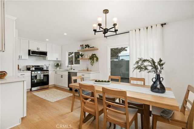 kitchen featuring sink, decorative light fixtures, white cabinets, and appliances with stainless steel finishes