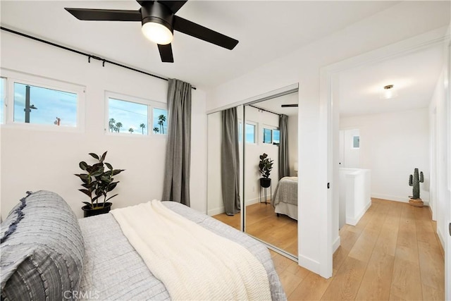 bedroom with light hardwood / wood-style flooring, a closet, and ceiling fan