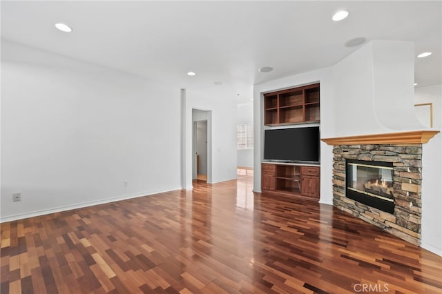 unfurnished living room with a fireplace, dark wood-type flooring, recessed lighting, and baseboards