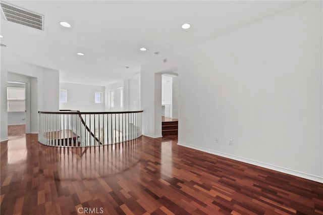 spare room featuring visible vents, recessed lighting, baseboards, and wood finished floors